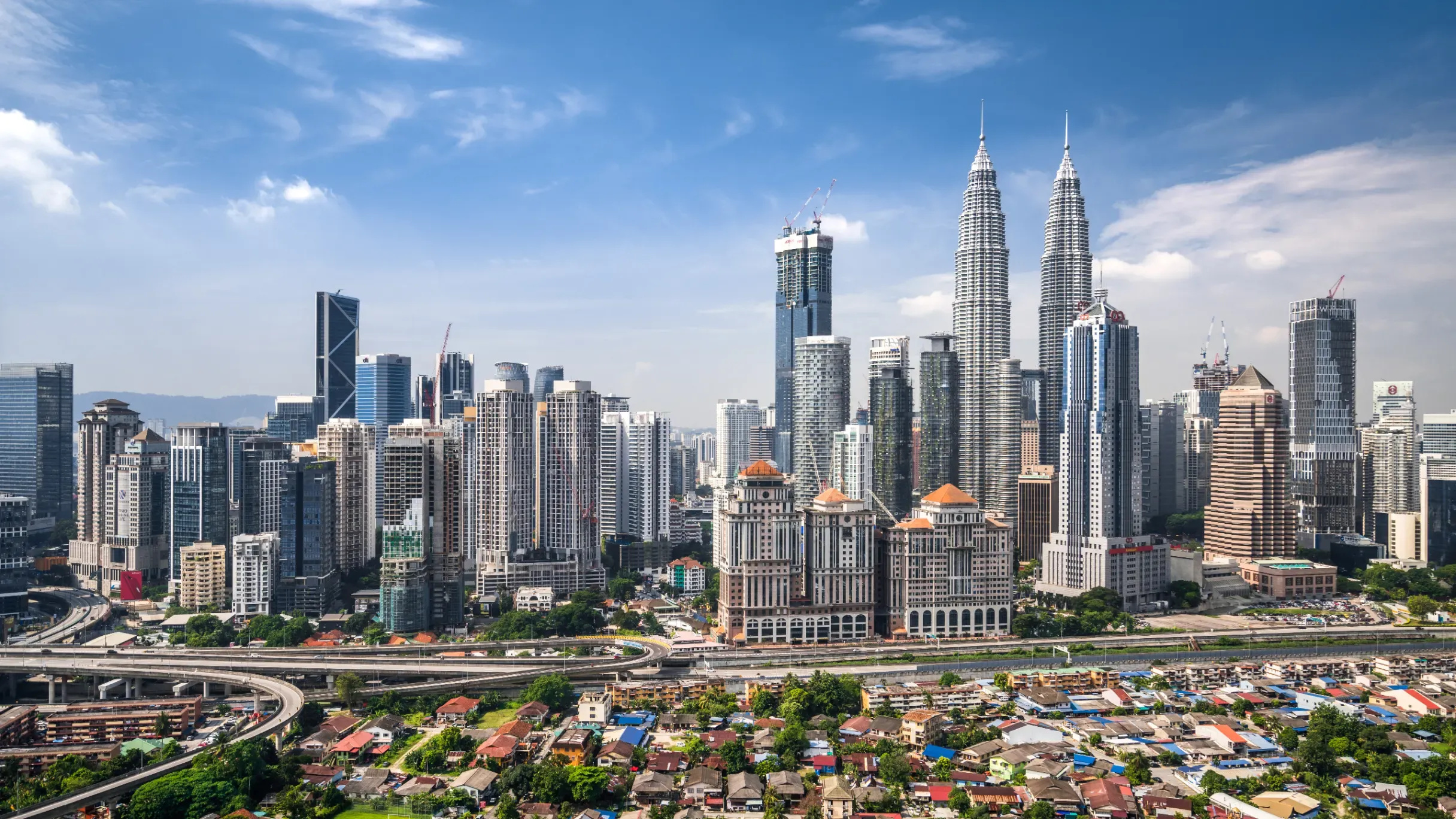 Aerial view of Kuala Lumpur’s skyline featuring modern skyscrapers, commercial districts, and urban development. 