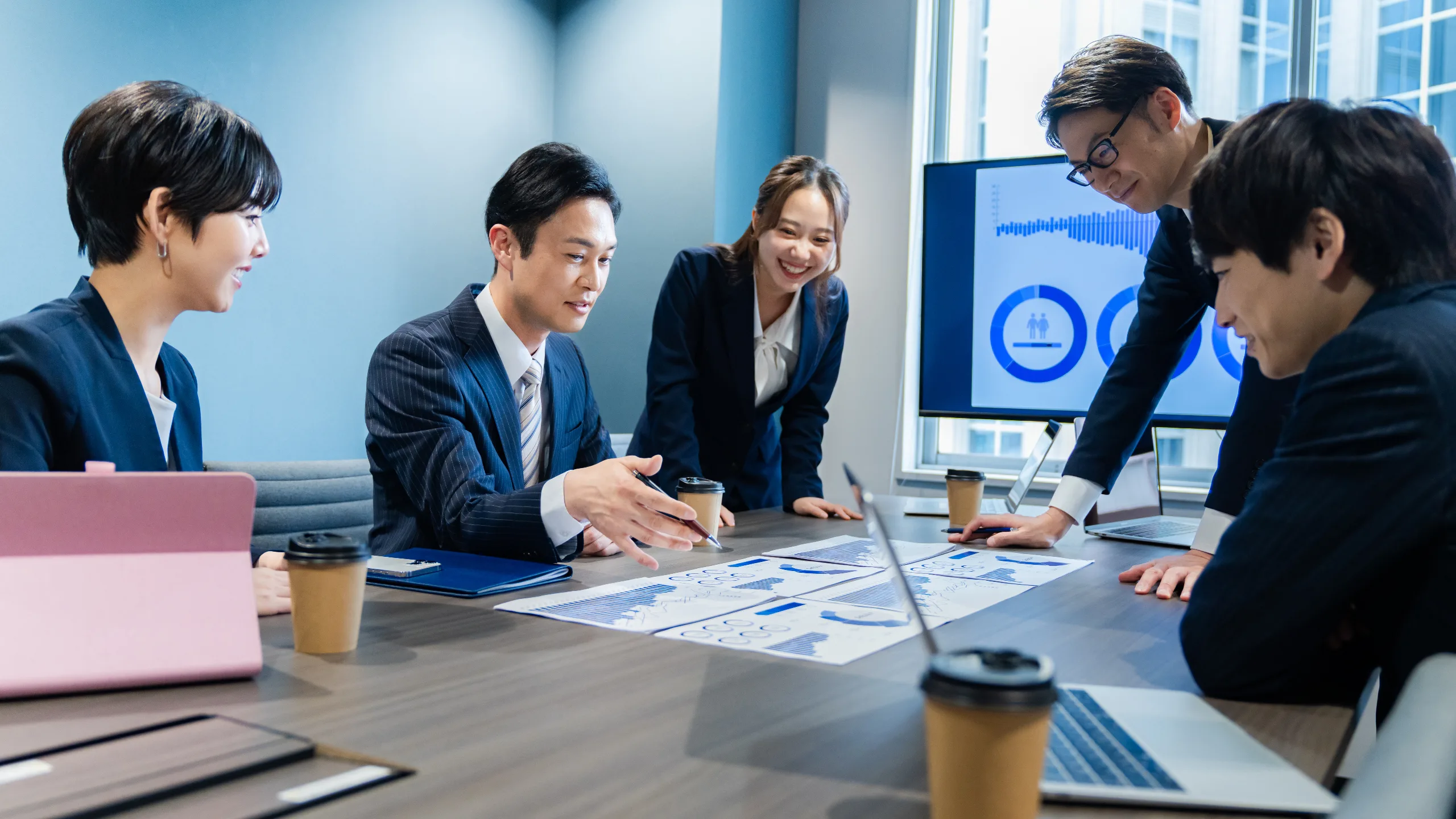 Business professionals in a meeting, collaborating and discussing plans in a modern office environment.