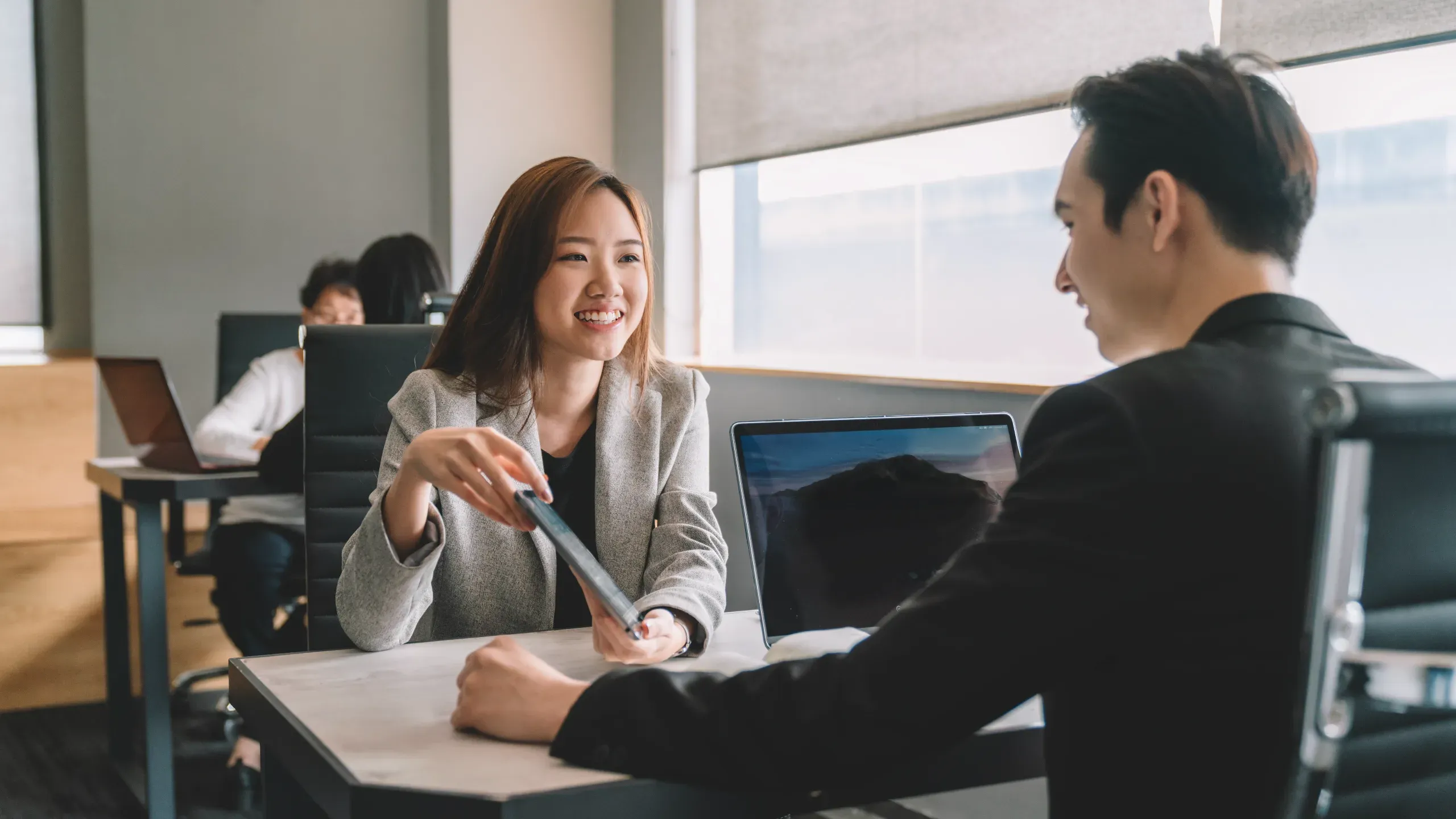Coworkers having a discussion in an office, collaborating in a professional environment. 