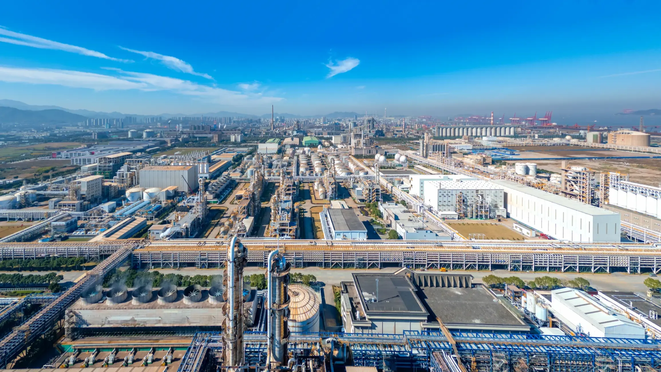 Aerial view of an industrial park featuring warehouses, manufacturing facilities, roads, and surrounding infrastructure. 