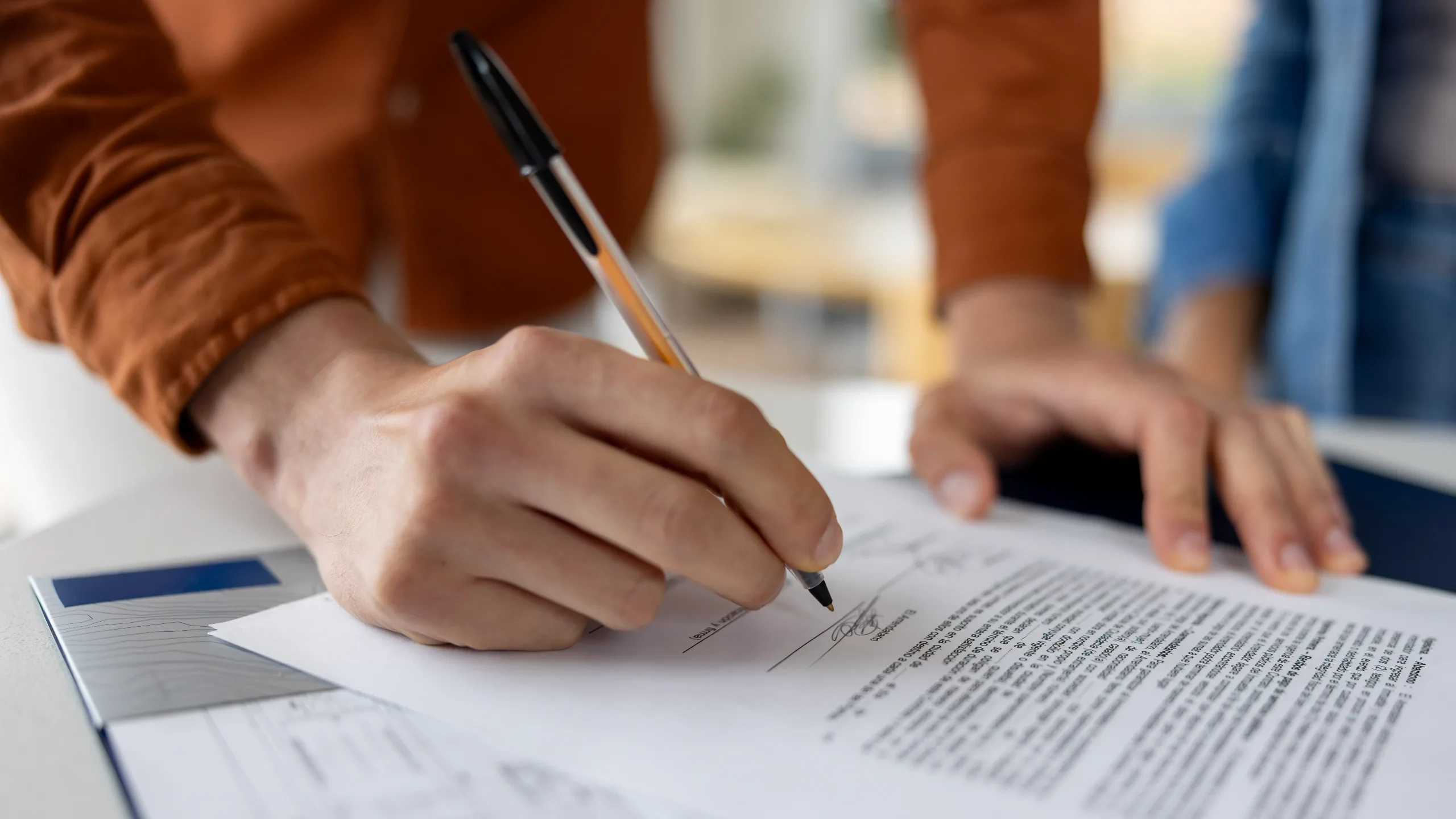 man signing a deed while buying a house
