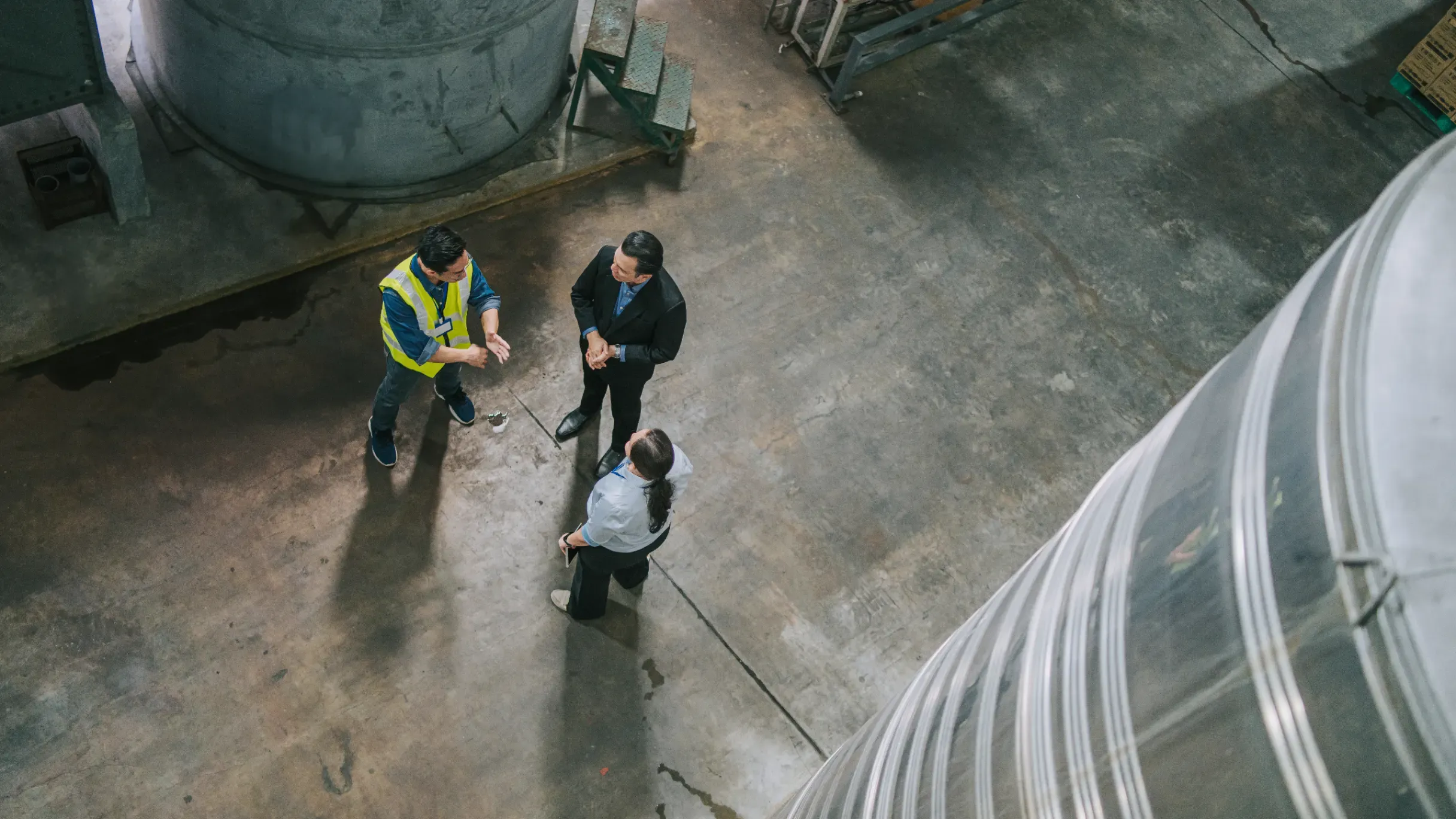 Three professionals discussing logistics operations in a warehouse. 
