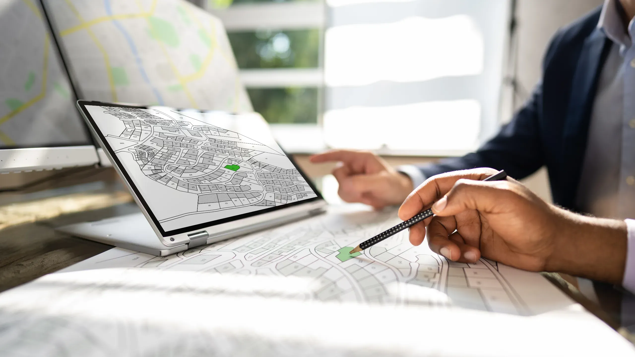 Workers undertaking a survey using maps and city planning information to assess urban development and infrastructure. 