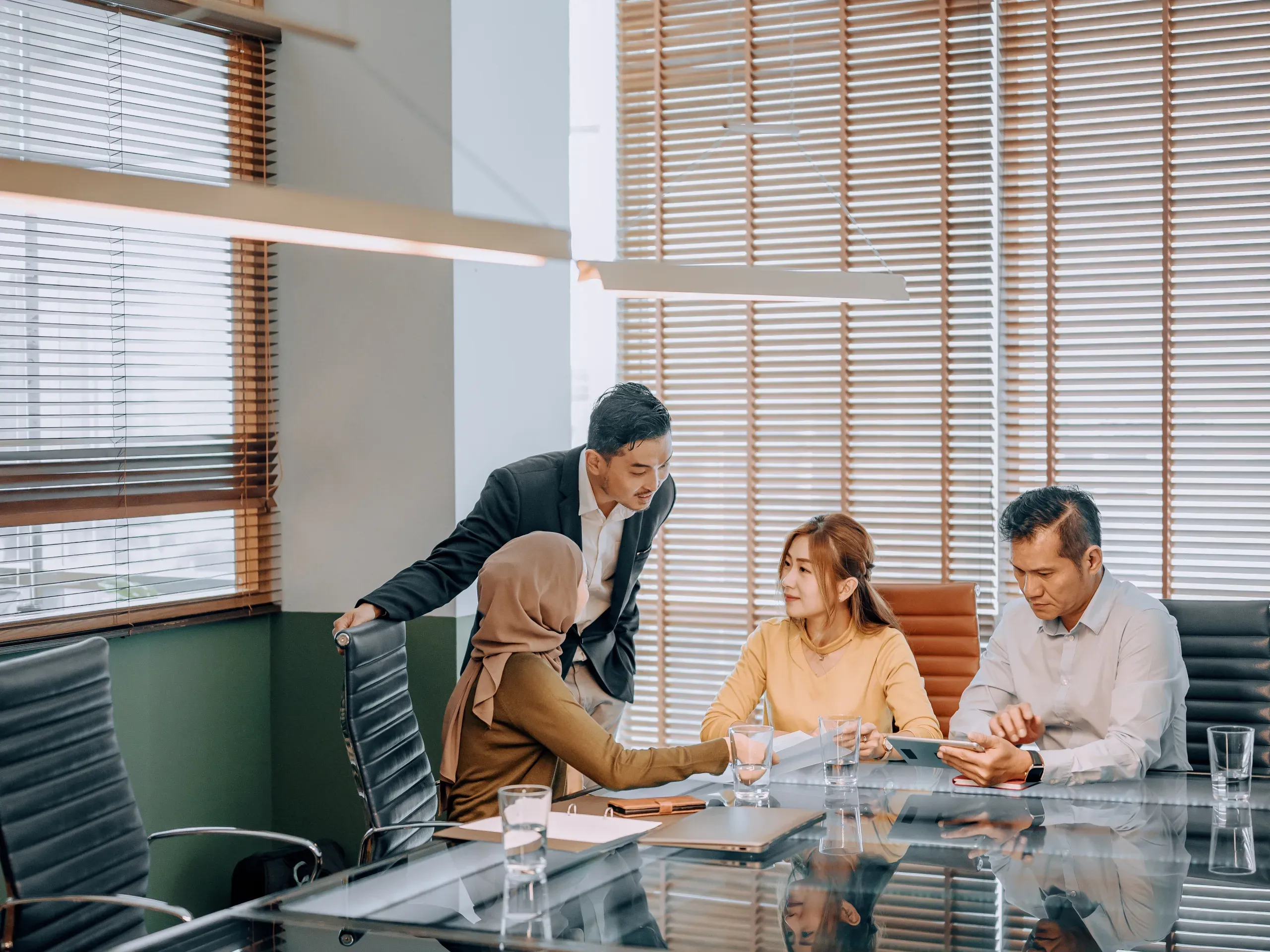 Asian entrepreneur meeting with coworkers in a modern meeting room, discussing business plans and collaborating on projects.