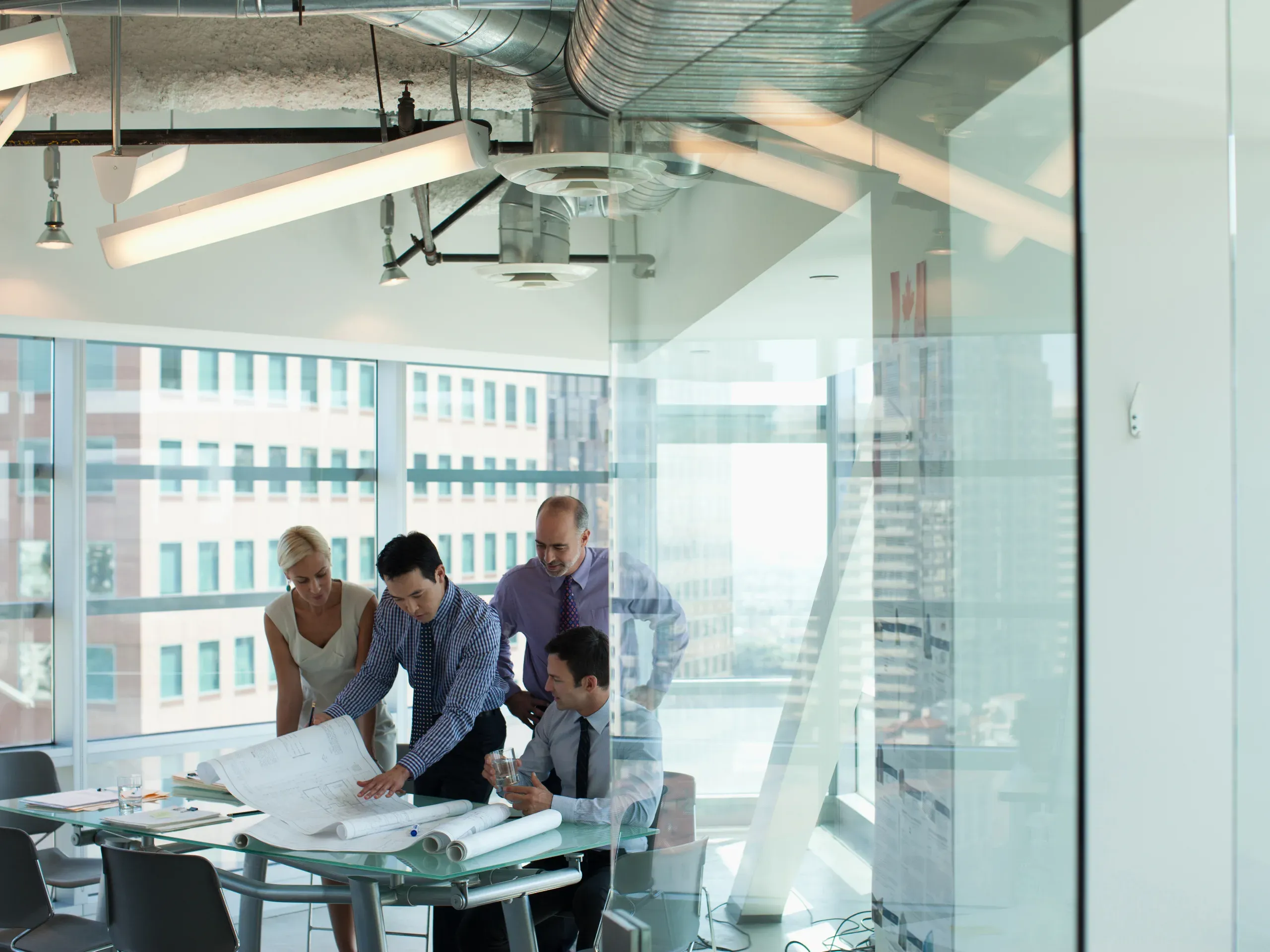 Business professionals talking in an office, engaged in discussion within a contemporary workplace. 