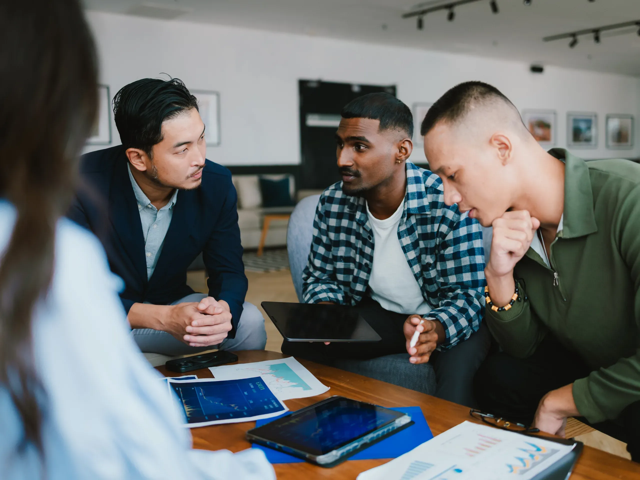 Diverse business team reviewing financial data during a strategy meeting, discussing performance and future plans. 