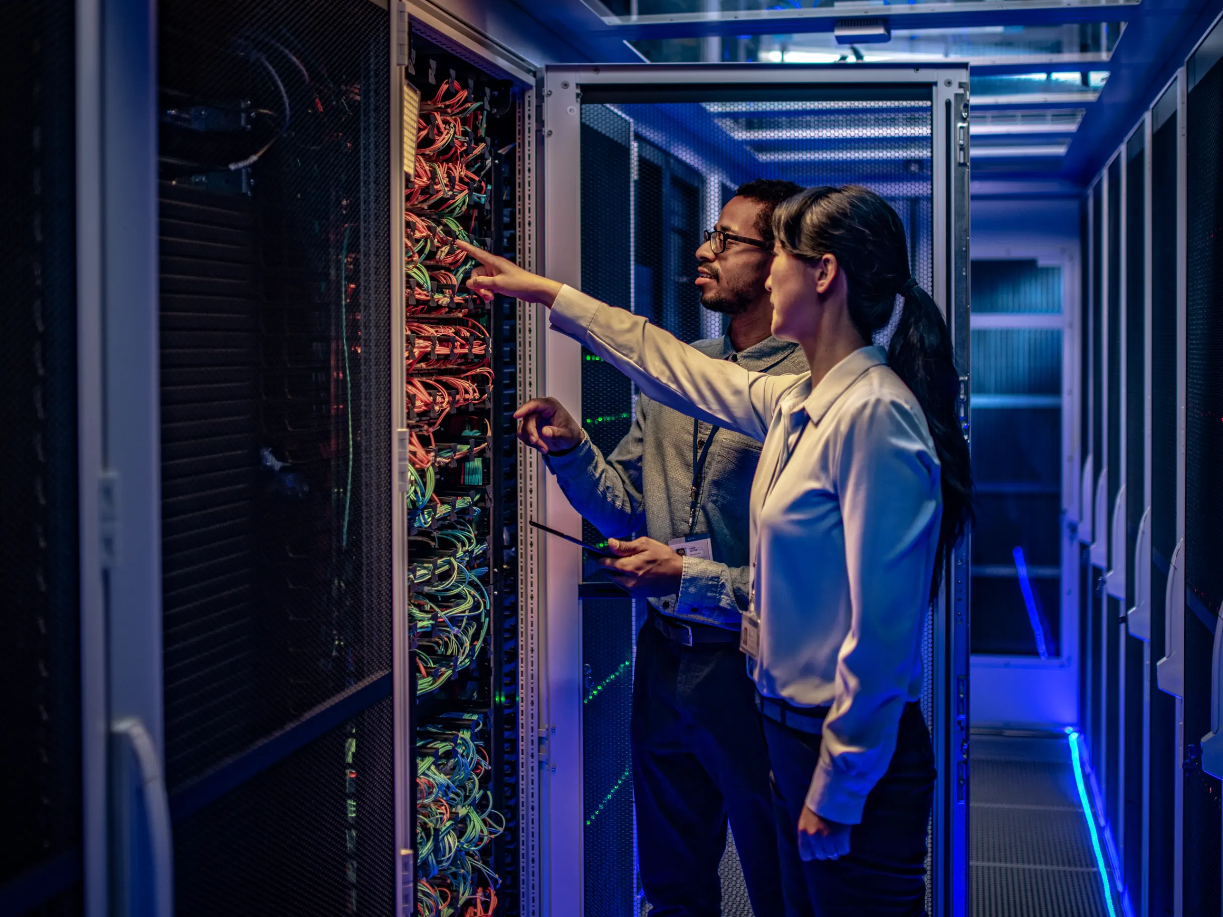 IT engineers checking servers in a data centre, monitoring systems and maintaining technology infrastructure.