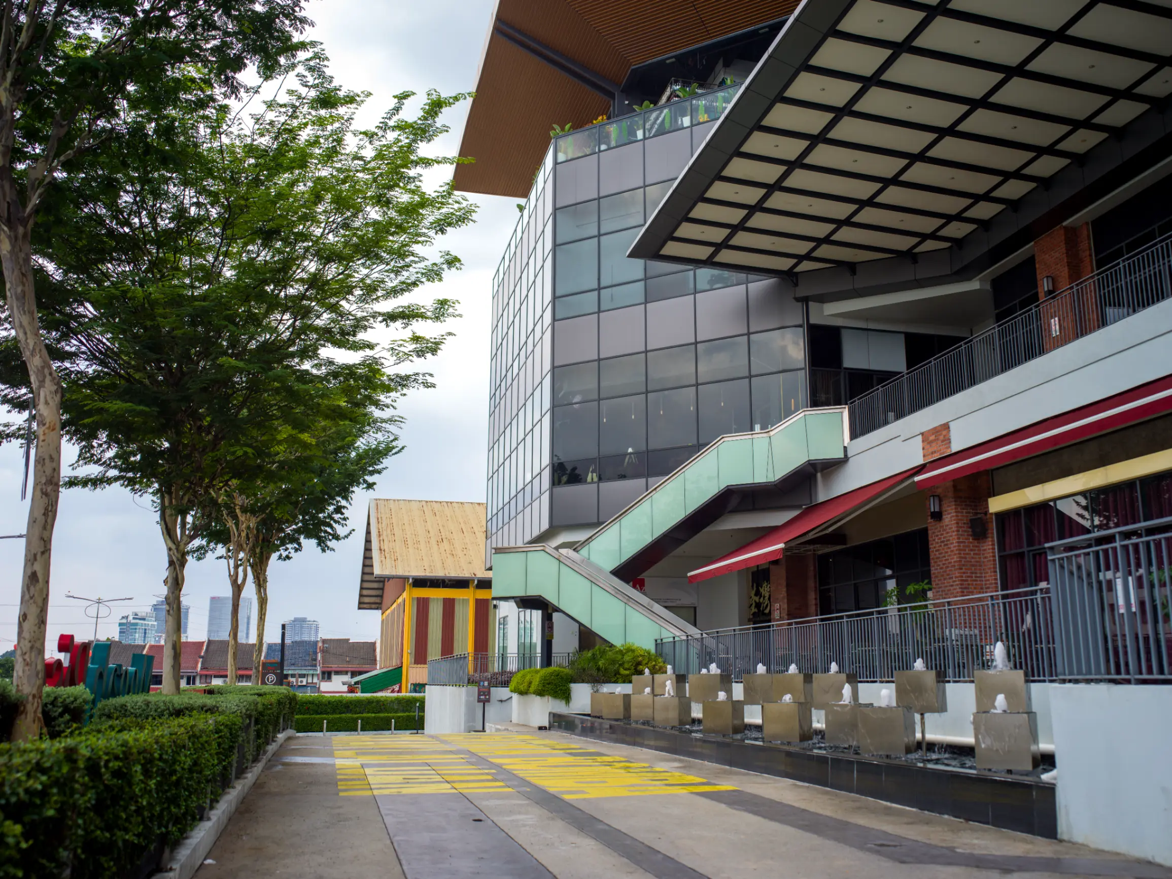 Modern mixed-use commercial development featuring contemporary architecture, an urban plaza, and decorative fountains.