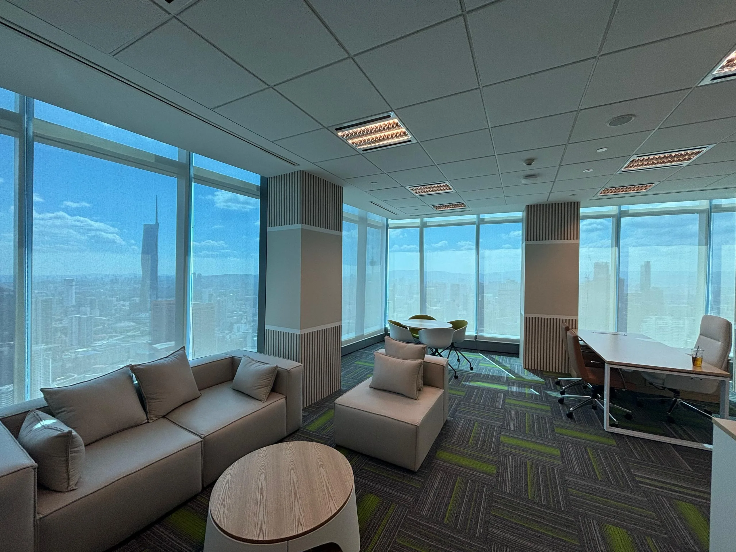 Modern office interior with large windows offering panoramic views across the city skyline.