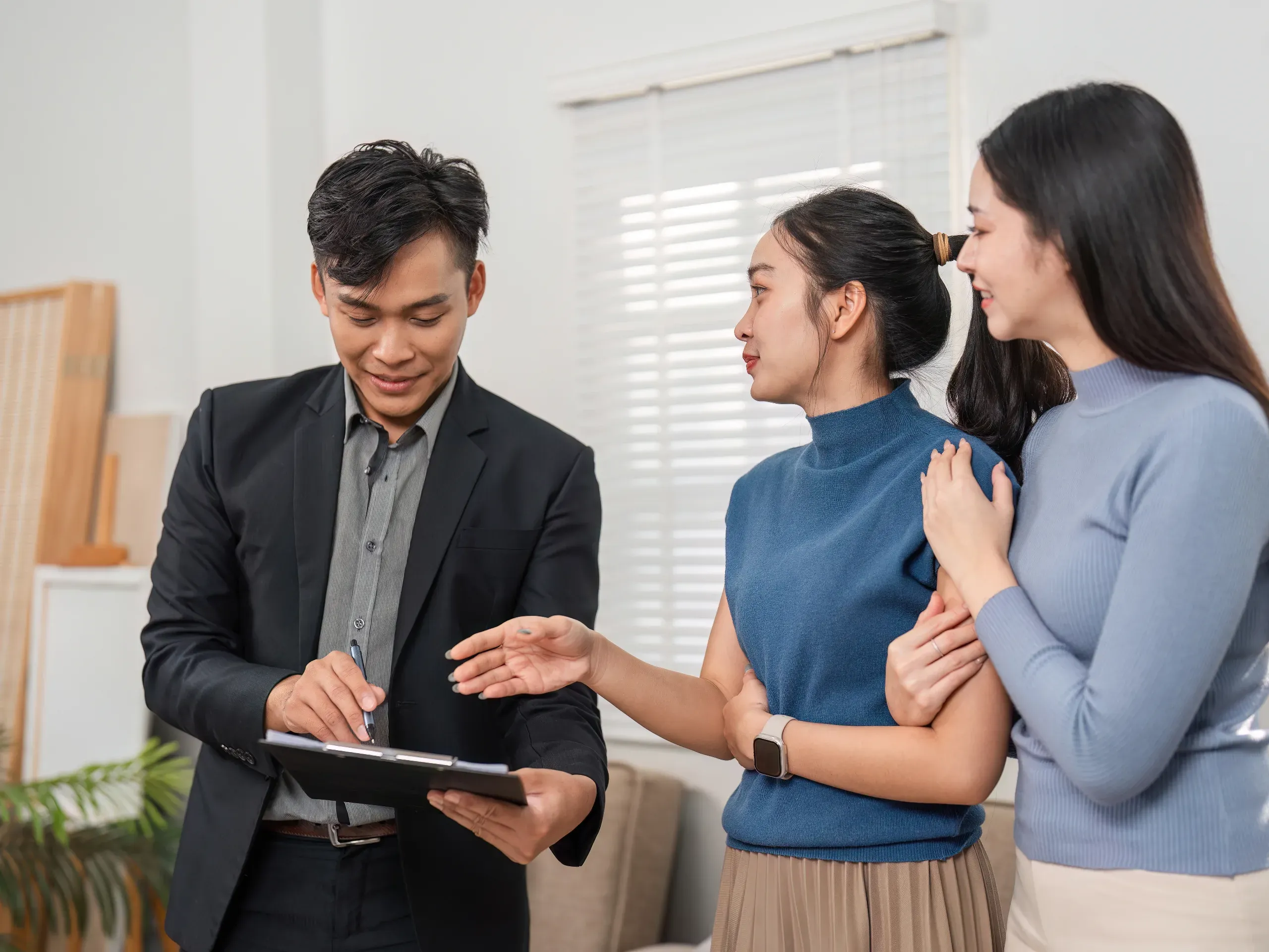 Real estate agent discussing property details with two prospective purchasers