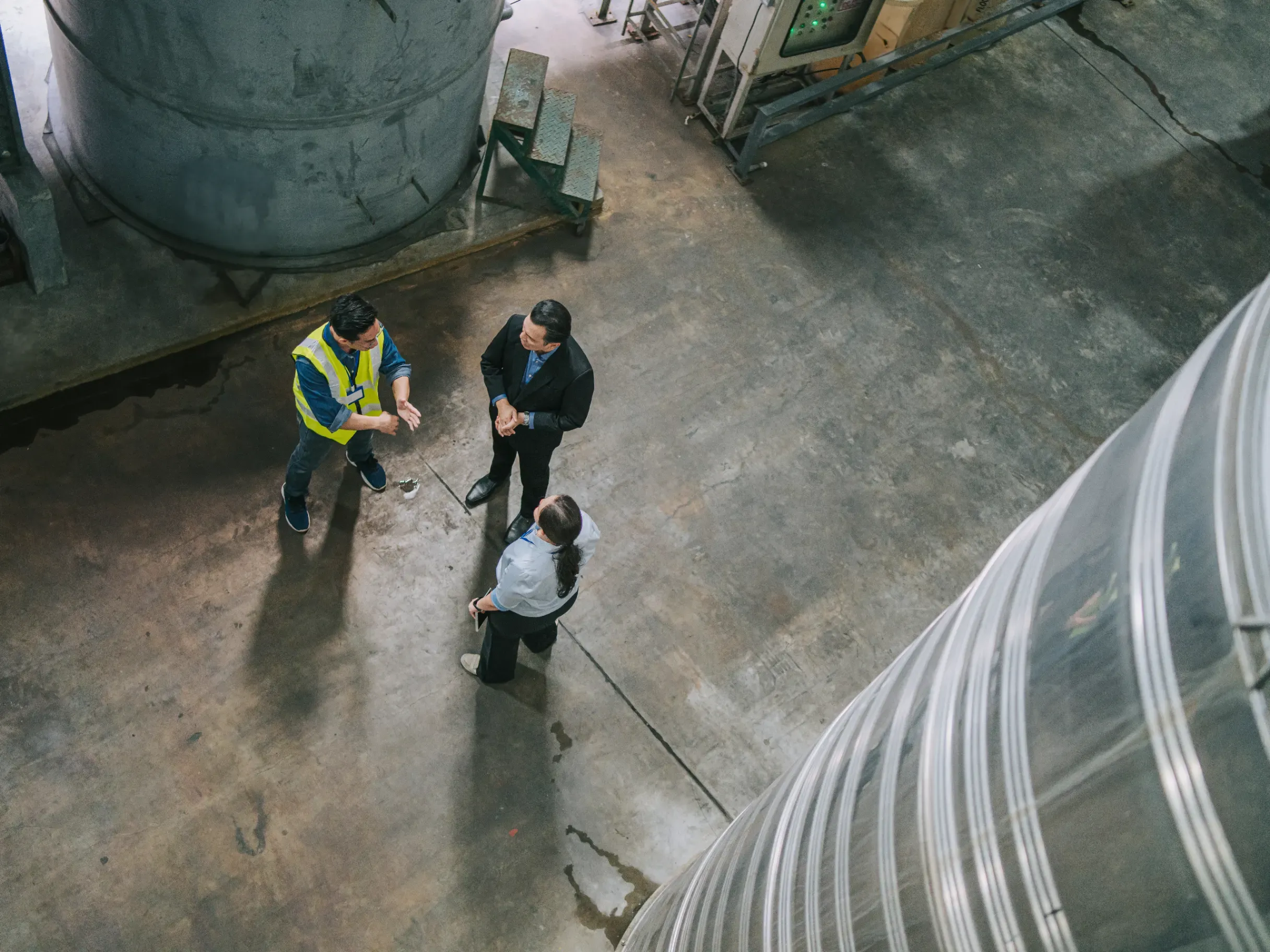 Three professionals discussing logistics operations in a warehouse. 