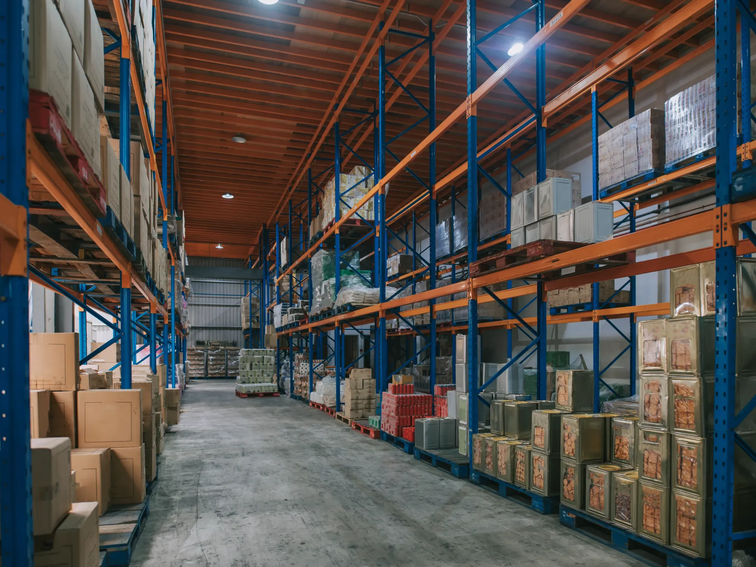 Warehouse with tall shelving units stocked with inventory, products, and packaged goods. 