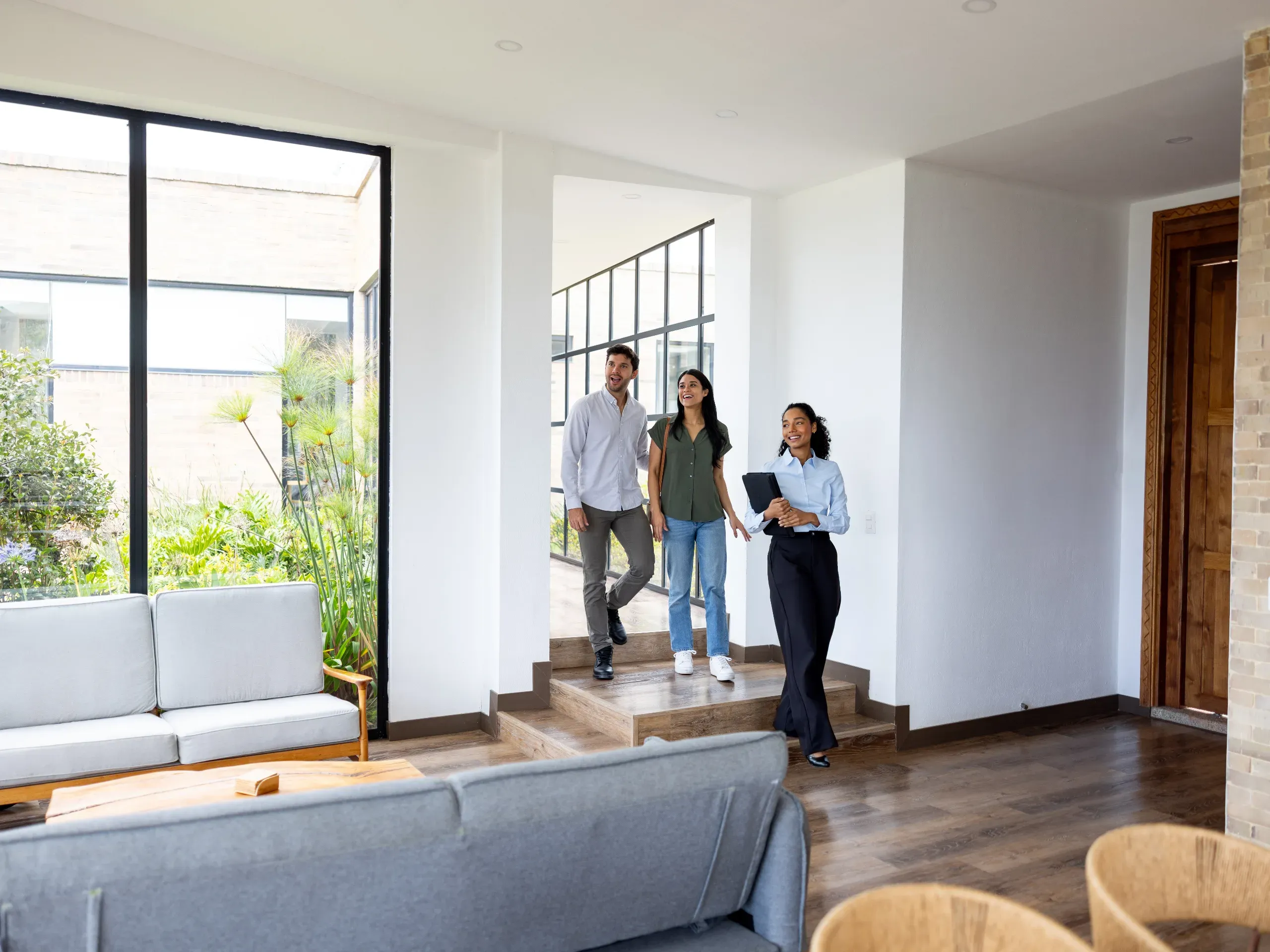 Couple viewing a house for sale with a real estate agent, discussing property features and purchase options