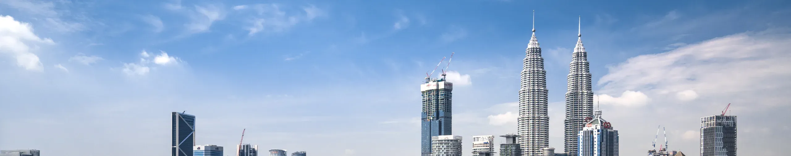 Aerial view of Kuala Lumpur’s skyline featuring modern skyscrapers, commercial districts, and urban development. banner