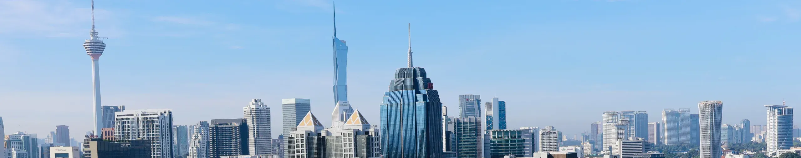 Daytime view of Kuala Lumpur, featuring a skyline of modern buildings and bustling urban development. banner