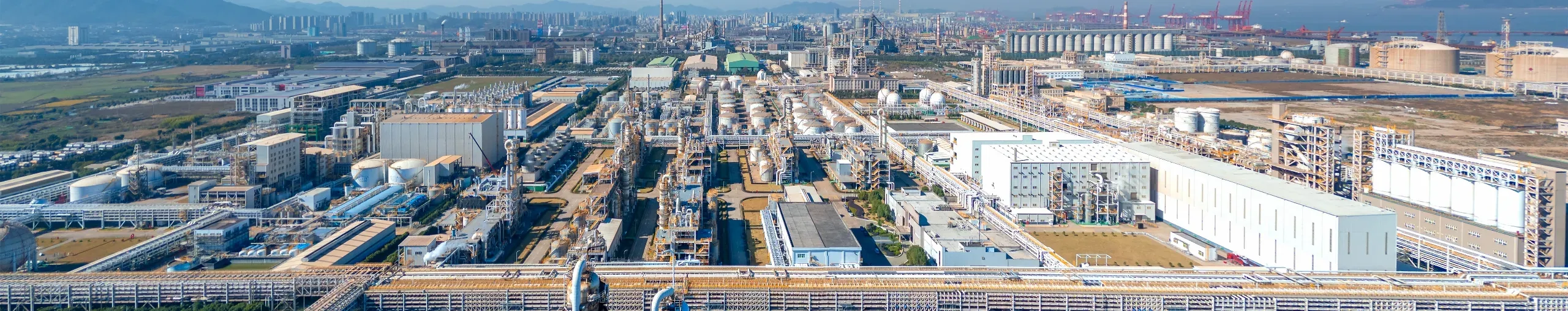 Aerial view of an industrial park featuring warehouses, manufacturing facilities, roads, and surrounding infrastructure - banner