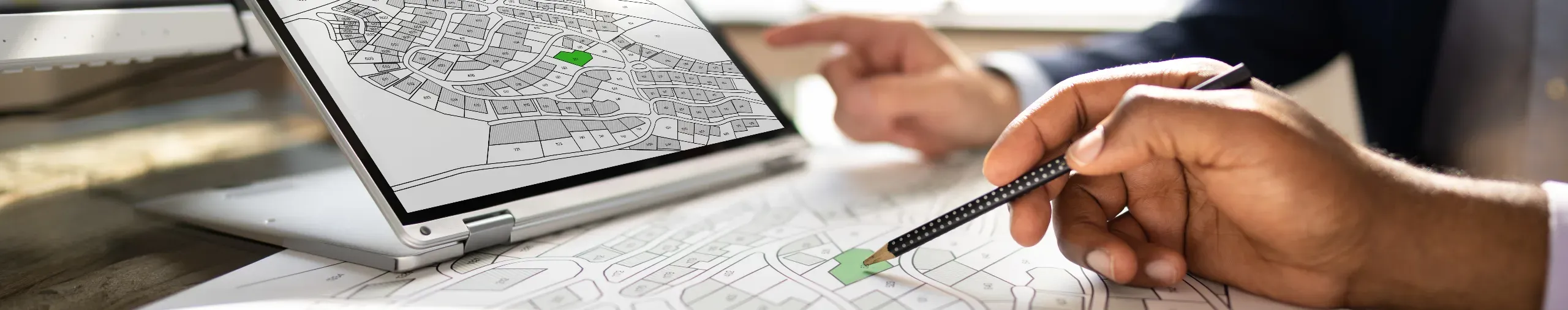 Workers undertaking a survey using maps and city planning information to assess urban development and infrastructure. 